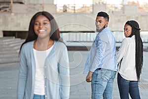 Unfaithful guy staring at another woman while walking with girlfriend outdoors