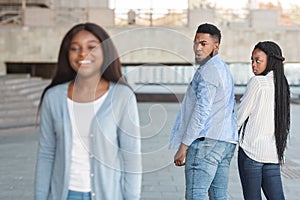 Unfaithful guy staring at another woman while walking with girlfriend outdoors photo