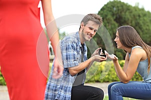 Unfaithful man looking another girl during proposal photo