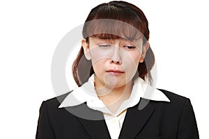 Unfashionable Asian businesswoman cries