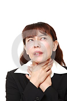 Unfashionable Asian businesswoman having throat pain