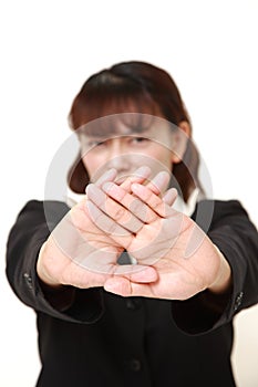 Unfashionable Asian businesswoman making stop gesture