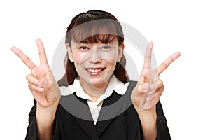 Unfashionable Asian businesswoman showing a victory sign