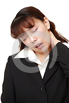 Unfashionable Asian businesswoman suffers from neck ache