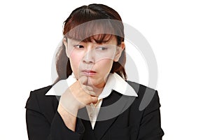 Unfashionable Asian businesswoman worries about something