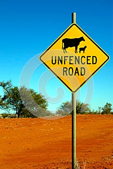 Unfenced Road warning sign indicating likely sheep and cattle on the road ahead.
