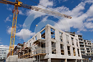 Unfinished brick apartment building under construction and a tall crane