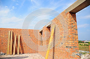 Unfinished brick house construction. Building new brick house with concrete lintel and with unfinished ceiling, roof.