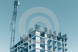 Unfinished building with falsework against blue sky background photo