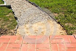 Unfinished building path of red concrete tiles