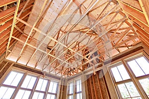 Unfinished framing beams on wooden house in construction site of a new home