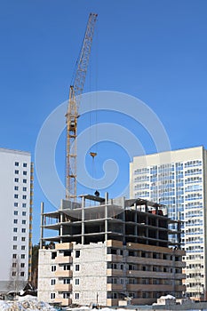 Unfinished high-rise building and working crane