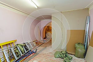 Unfinished interior of upgrade room with ladder and constructional materials during on the remodeling, renovating, extension, res photo