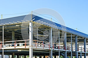Unfinished metal frame of a new modern industrial building with utilities