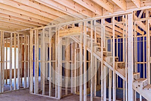 An unfinished residential home under construction is framed out with a wooden beam supports
