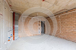 Unfinished room interior of building under construction. Brick red walls. New home