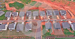 The unfinished subdivision construction site of an incomplete neighborhood housing is seen from the air
