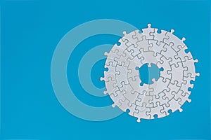Unfinished white jigsaw puzzle pieces on blue background, The last missing piece of the jigsaw puzzle