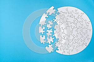 Unfinished white jigsaw puzzle pieces on blue background, The last piece of jigsaw puzzle, Copy space