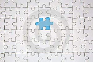 Unfinished white jigsaw puzzle pieces on blue background, The last piece of jigsaw puzzle, Copy space