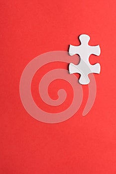 Unfinished white jigsaw puzzle pieces on red background