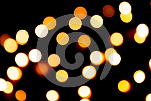 Unfocused abstract gold bokeh on black background. defocused and blurred many round light