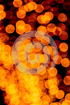 Unfocused abstract orange bokeh on black background. defocused and blurred many round light