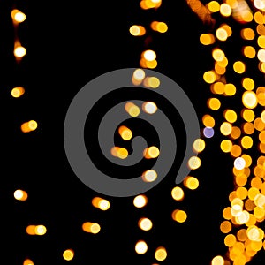 Unfocused abstract yellow bokeh on black background. defocused and blurred many round light