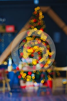 unfocused. a large Christmas tree decorated in a room with a black wall. blur