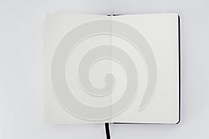 Unfold open notebook with blank white pages on light back. Sketchbook, book