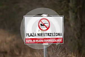 Unguarded beach sign in Polish on the beach
