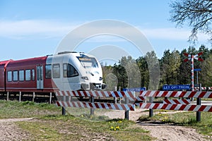 Unguarded level crossing with passing train photo