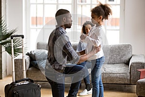 Unhappy African American father saying goodbye to daughter