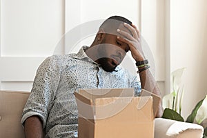 Unhappy african american male recipient recieved damaged item. photo
