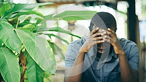 Unhappy african man having puzzled expression, holding hand on his head. Black guy stressting and headache