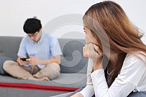 Unhappy angry asian woman after arguing with boyfriend in living room. Bad relationship couple concept.