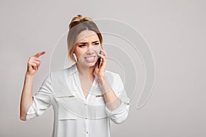 Unhappy angry woman talking on phone over background