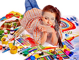 Unhappy artist woman lying on paint palette