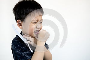 Unhappy asian child boy suffering from cough,sore throat in rainy season,respiratory tract infection,unwell kid has seasonal