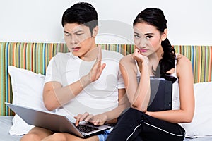 Unhappy Asian couple having issues surfing the internet