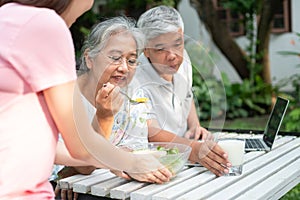 Unhappy Asian senior woman anorexia and say no to meals, Elderly live with family and caregivers try feed food and old woman no
