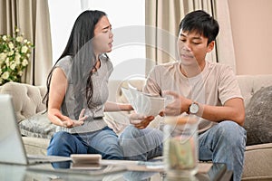 Unhappy Asian spouses are arguing about unexpected high household bills and credit card invoices