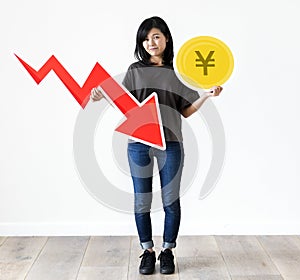 Unhappy Asian woman holding a Japanese Yen and financial decrease arrow