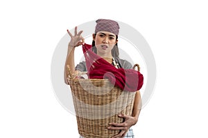 Unhappy Asian woman smells dirty laundry from basket isolated on white background