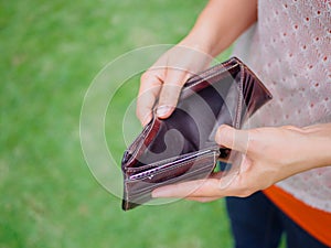 Unhappy bankrupt woman with empty wallet