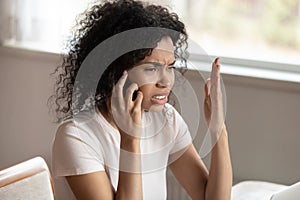 Unhappy biracial woman having unpleasant cellular call