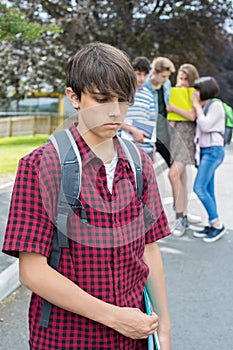 Unhappy Boy Being Gossiped About By School Friends