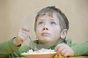 Unhappy Boy Eating Food While Looking Up