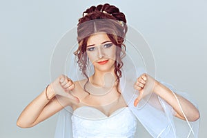 Unhappy bride. Woman with thumbs down gesture isolated light blue background wall. Studio shot horizontal image. Body language,