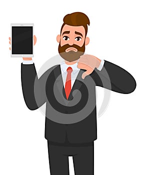 Unhappy business man showing/holding blank screen of new digital tablet computer and gesturing, making, showing thumbs down sign.